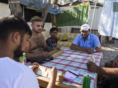 Sugli usci sono riuniti gruppi di uomini: alcuni giocano a un misterioso gioco con le carte